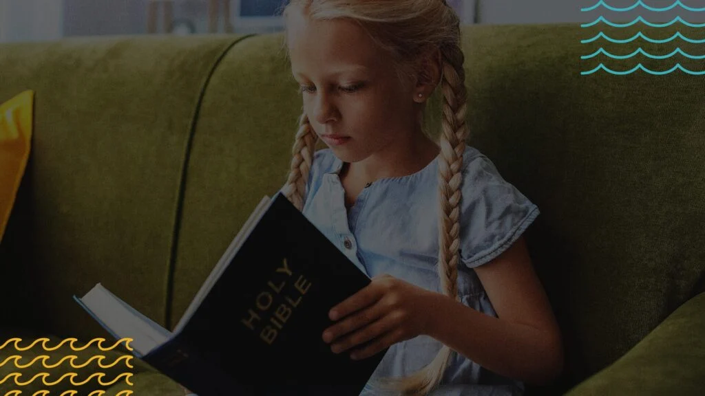 A young girl reading a Bible on a couch