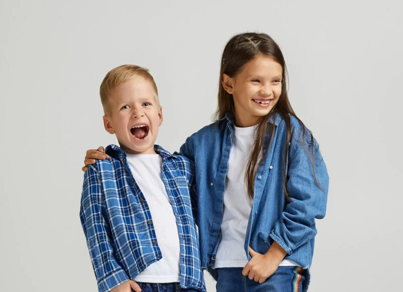 Two children in denim smiling together in kids ministry