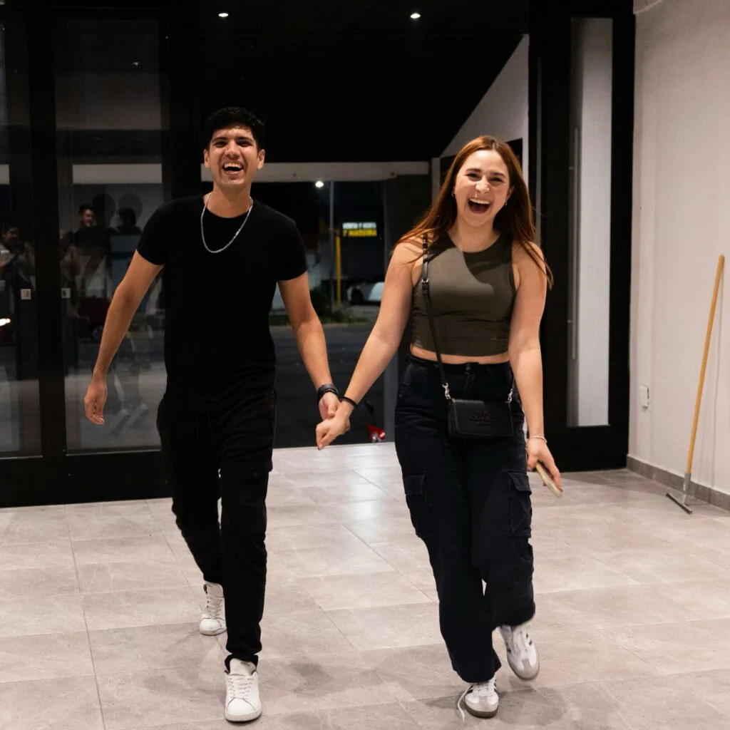 A young couple laughing and holding hands
