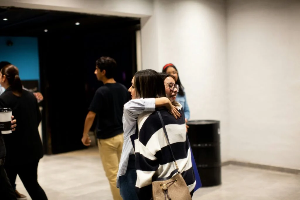 Two friends hugging in a hallway before service
